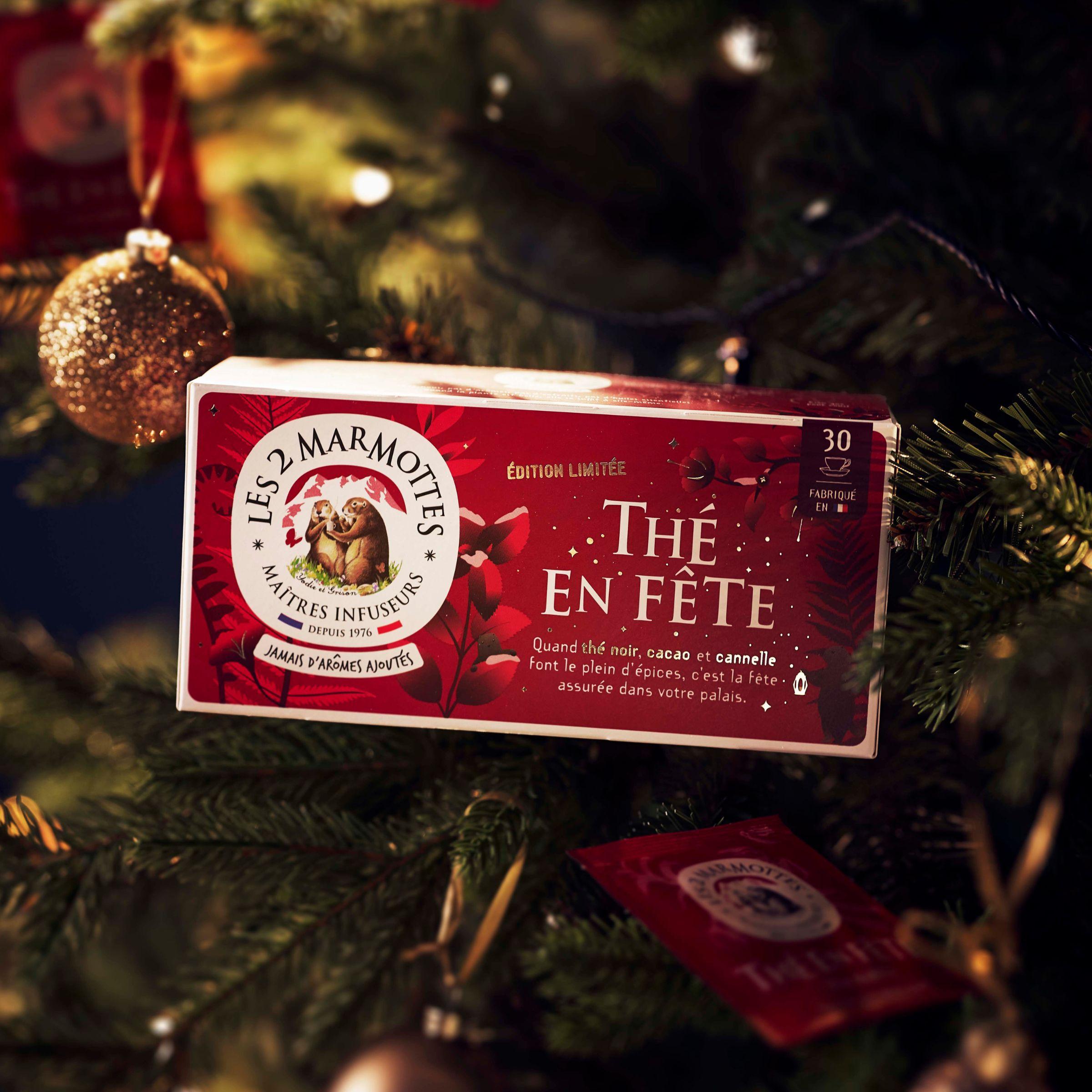 Thé de noel les 2 marmottes : thé en fête. Thé noir bio 100% plantes, sans arômes ajoutés. Thé noir, cacao, cannelle, pour un thé d'hiver réconfortant et chaleureux. Idée cadeau noel, idée cadeau secret santa. Fabriqué en France. Boîte de 30 sachets, décor festif rouge et or, illustrations de marmottes dans un décor hivernal. Edition limitée.