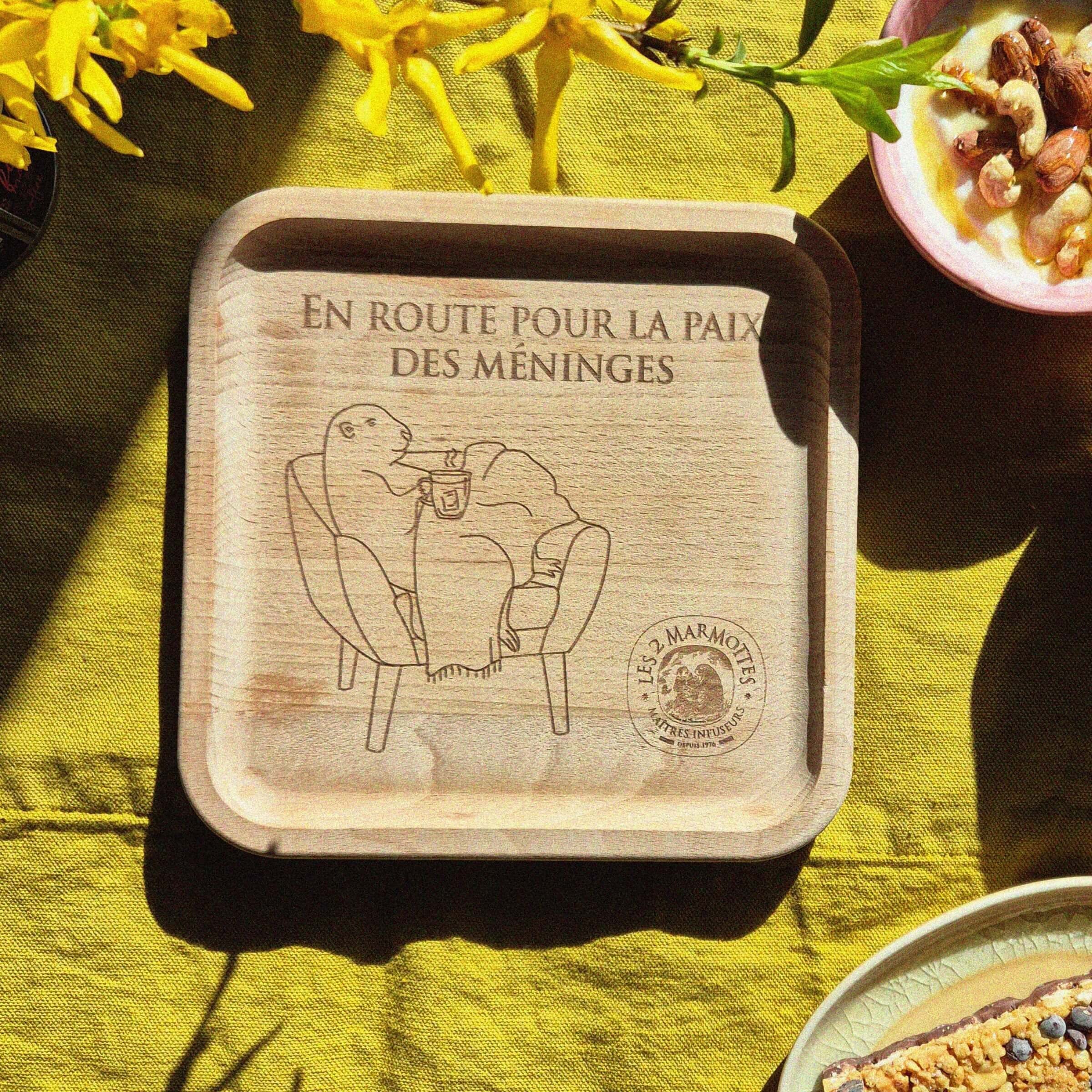 Petit plateau à thé carré en bois illustré d'une marmotte dans un fauteuil et d'une citation en route vers la paix des méninges