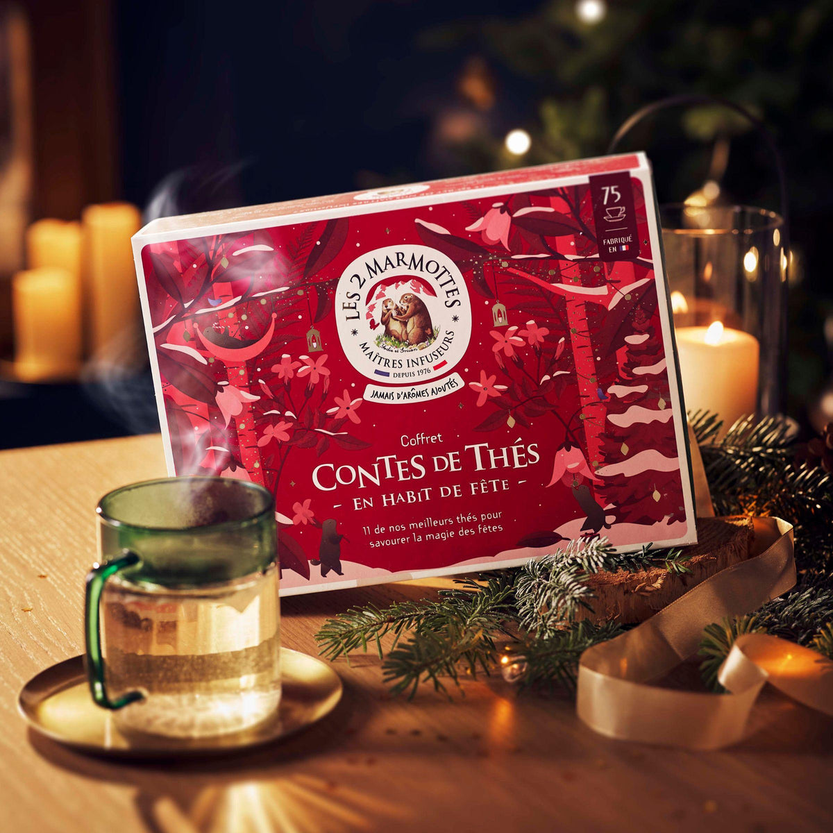 Coffret cadeau thés, coffret à offrir pour noel ou secret santa : 11 thés bios 100% plantes sans arômes ajoutés. Assortiment thés noirs bios et thés verts bios, 75 sachets en tout. Décor festif noel rouge et or, illustrations marmottes neige et plantes. Fabrication française, PME locale de Haute-Savoie Les 2 Marmottes. Savoir-faire thés et tisanes depuis 1976.